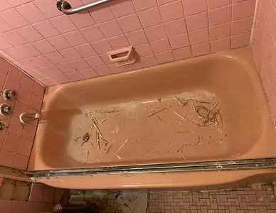 Old bathtub before resurfacing showing stains and discoloration