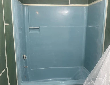 Shower stall before refinishing – stained fiberglass and dull texture.