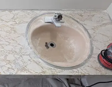 Old sink before refinishing showing stains and discoloration