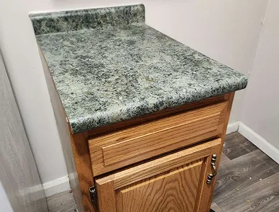 Countertop before refinishing – dull surface with stains and worn coating.